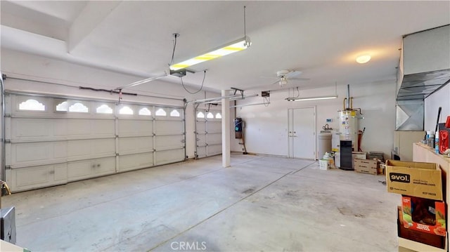 garage featuring a garage door opener, ceiling fan, and water heater