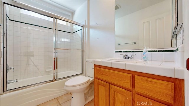 full bathroom featuring tile patterned flooring, vanity, toilet, and bath / shower combo with glass door