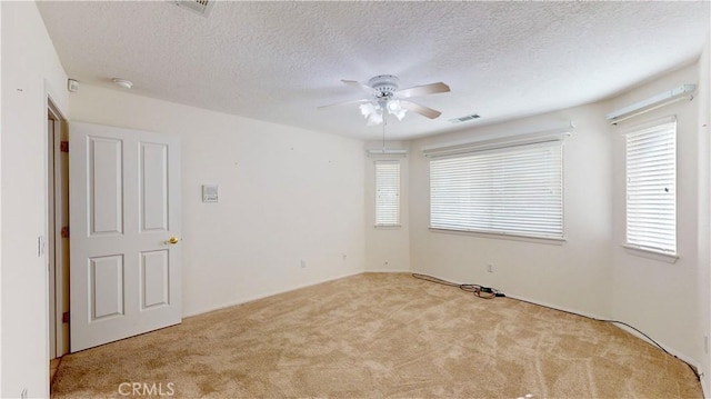 carpeted empty room featuring a textured ceiling and ceiling fan