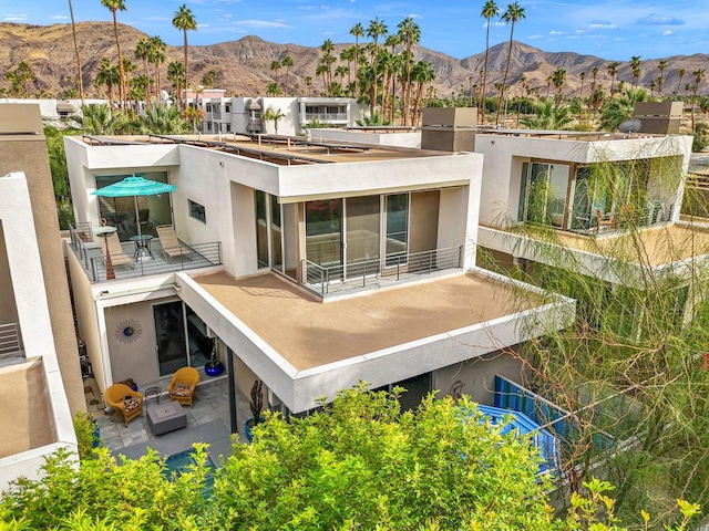 rear view of property featuring a mountain view and a balcony