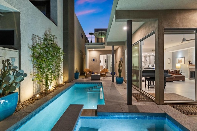 pool at dusk featuring outdoor lounge area and a patio