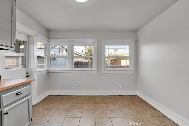 unfurnished dining area featuring light tile patterned flooring