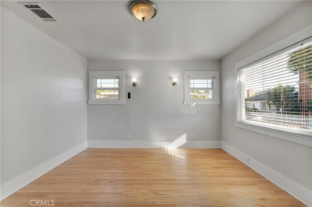 spare room featuring plenty of natural light and light hardwood / wood-style floors