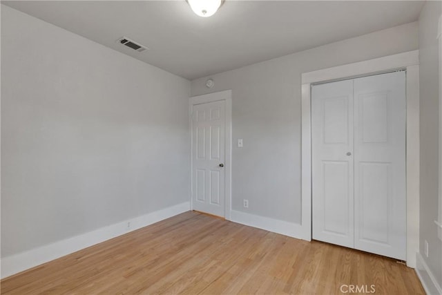 unfurnished bedroom with a closet and hardwood / wood-style floors