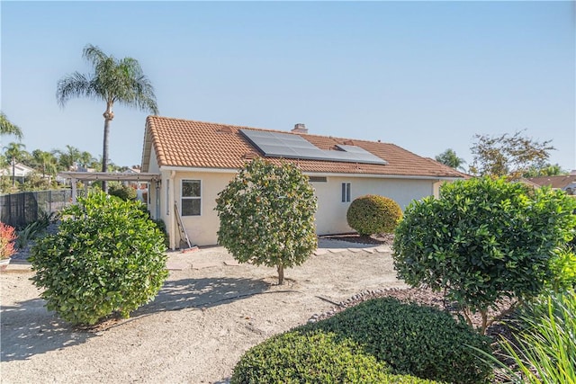 rear view of property featuring solar panels