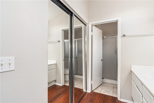 bathroom with hardwood / wood-style floors, vanity, toilet, and an enclosed shower