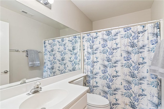 bathroom with walk in shower, vanity, and toilet