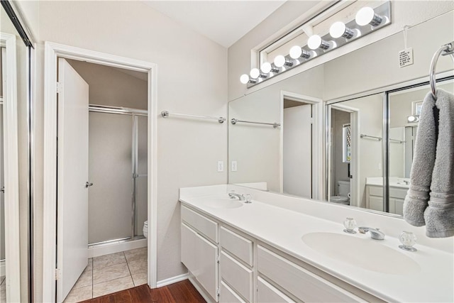 bathroom with tile patterned floors, vanity, toilet, and walk in shower