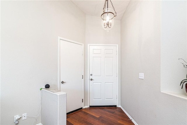 entryway with dark hardwood / wood-style flooring and an inviting chandelier