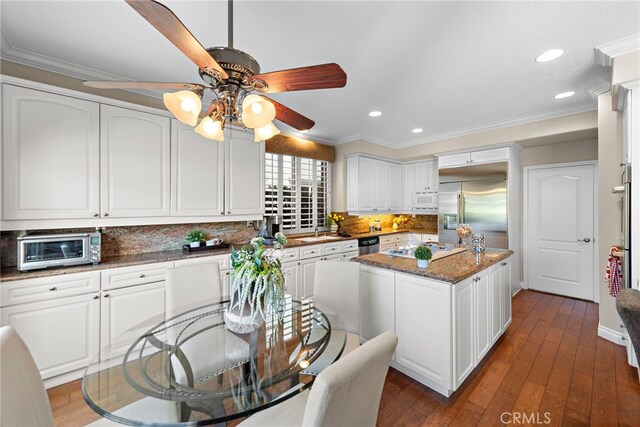 kitchen featuring white cabinetry, dark hardwood / wood-style flooring, a center island, and appliances with stainless steel finishes