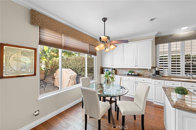 dining area featuring crown molding, recessed lighting, light wood-style flooring, a ceiling fan, and baseboards