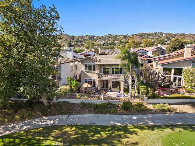 view of front of property featuring a mountain view and a balcony