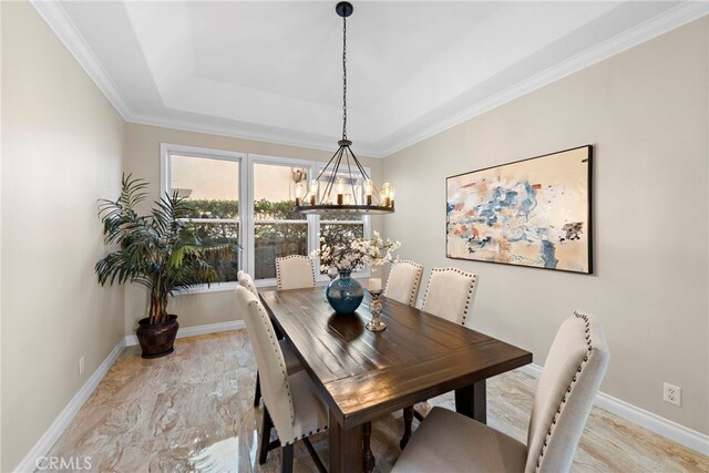 dining room with a tray ceiling, a chandelier, and ornamental molding