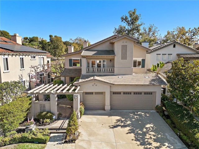 mediterranean / spanish home with an attached garage, fence, concrete driveway, a tiled roof, and stucco siding