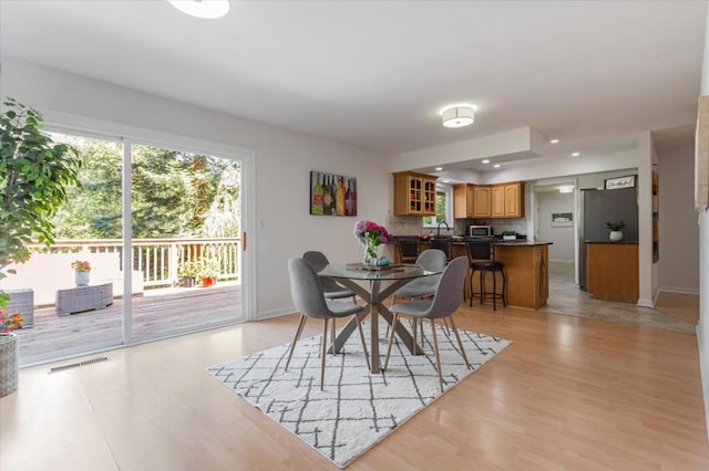 dining space featuring sink and light hardwood / wood-style floors