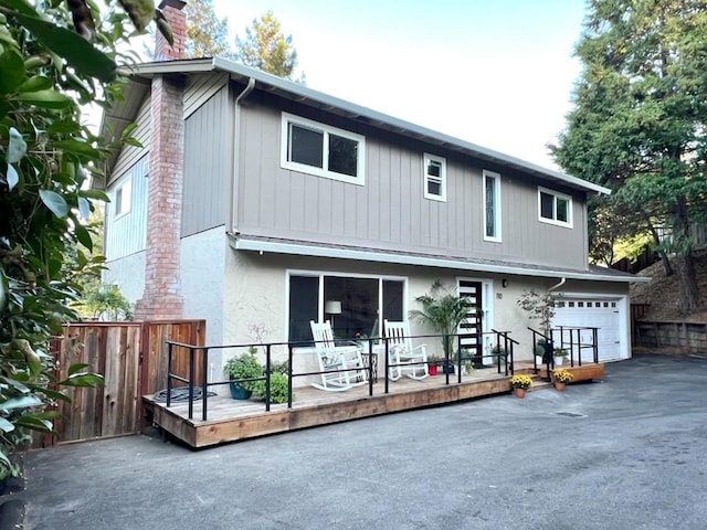 back of house with a garage and a wooden deck