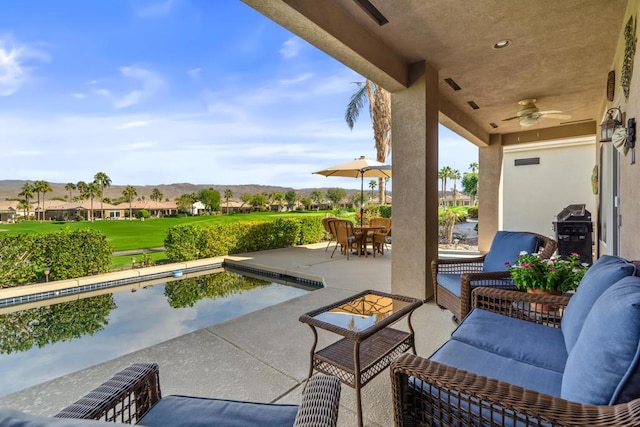 view of patio / terrace with ceiling fan, an outdoor hangout area, and a mountain view