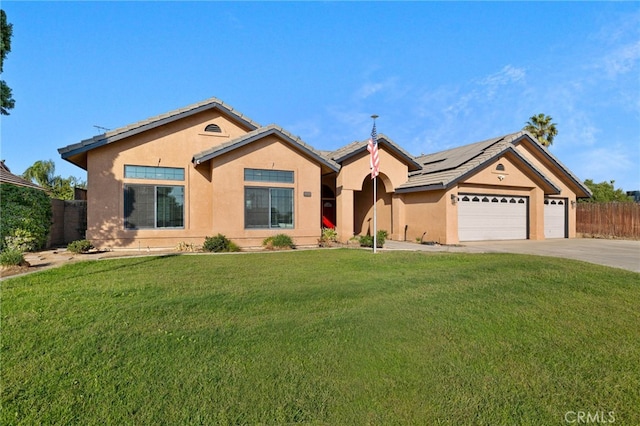 ranch-style home featuring solar panels, a garage, and a front lawn