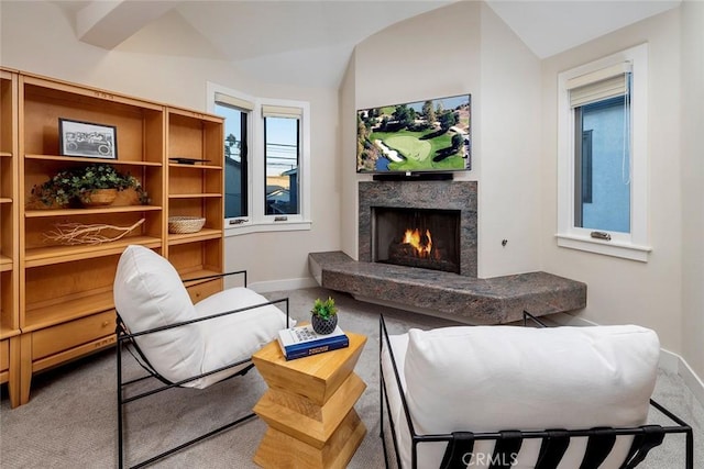 carpeted living room with vaulted ceiling and a premium fireplace