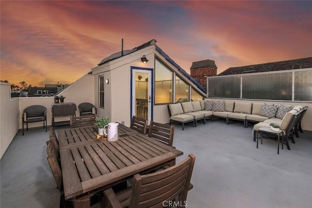 patio terrace at dusk featuring an outdoor hangout area