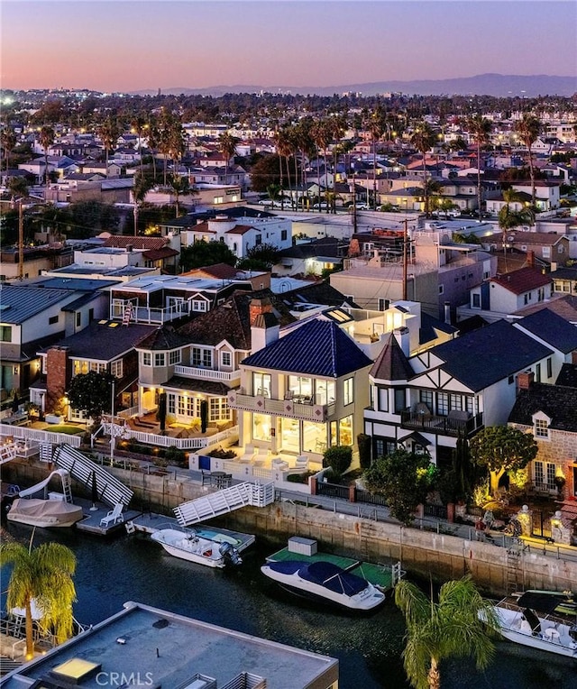 aerial view at dusk featuring a water view