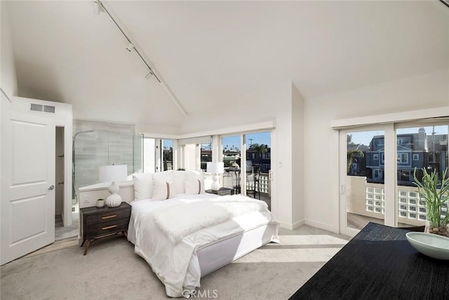 carpeted bedroom featuring rail lighting, access to outside, and high vaulted ceiling