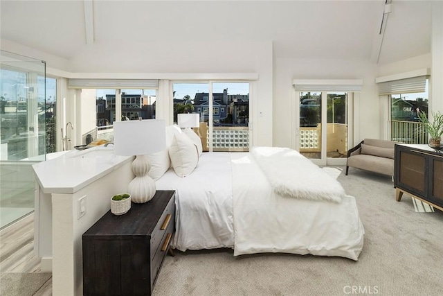 bedroom featuring access to outside and light colored carpet