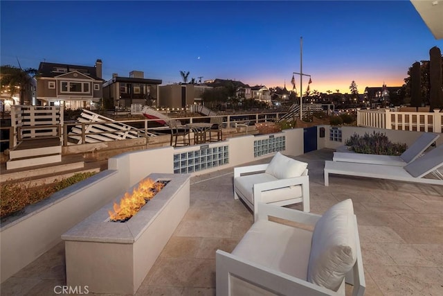 patio terrace at dusk with an outdoor living space with a fire pit