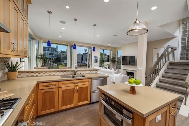 kitchen featuring sink, hanging light fixtures, appliances with stainless steel finishes, tasteful backsplash, and dark hardwood / wood-style flooring