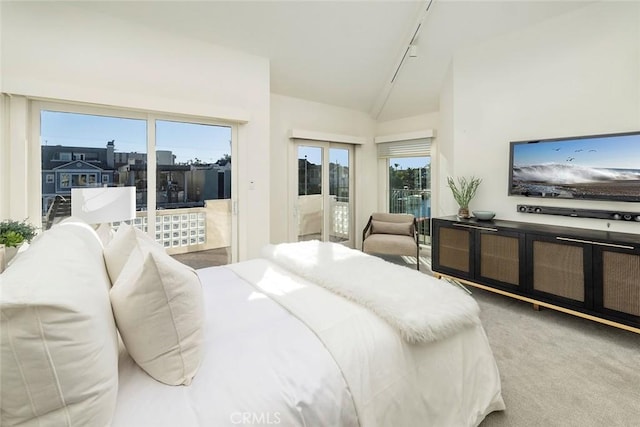 carpeted bedroom featuring access to outside, multiple windows, and vaulted ceiling