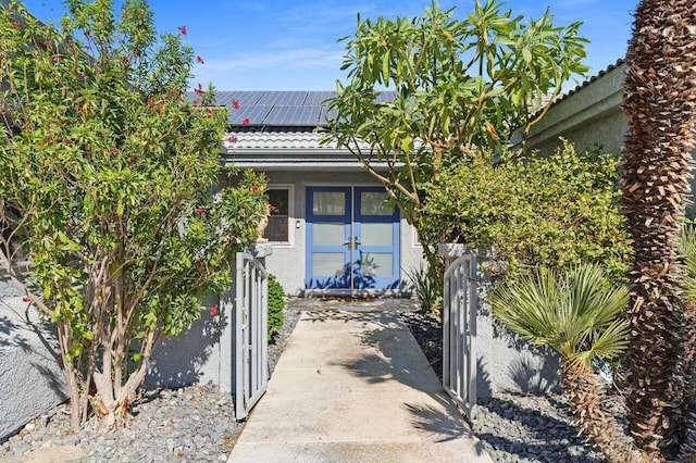 entrance to property featuring french doors and solar panels