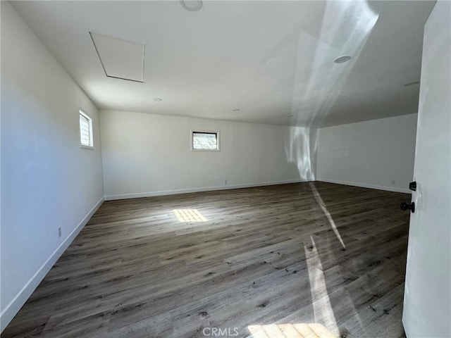 additional living space with dark hardwood / wood-style floors and a healthy amount of sunlight