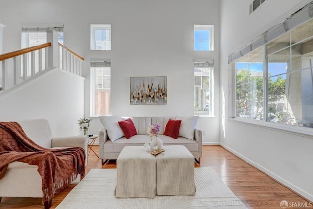 living room with hardwood / wood-style floors and a high ceiling