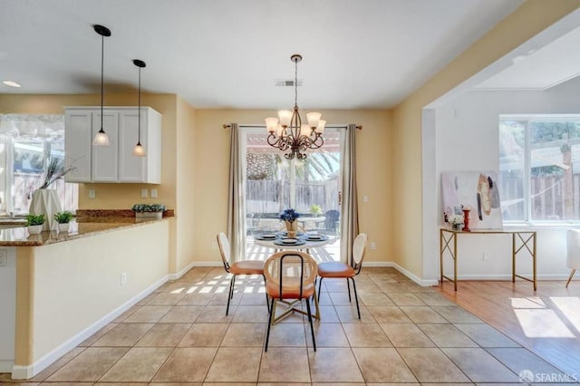 tiled dining space with a chandelier