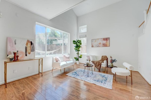 sitting room featuring light hardwood / wood-style flooring and a high ceiling