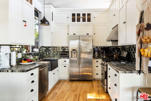 kitchen with pendant lighting, white cabinetry, and appliances with stainless steel finishes