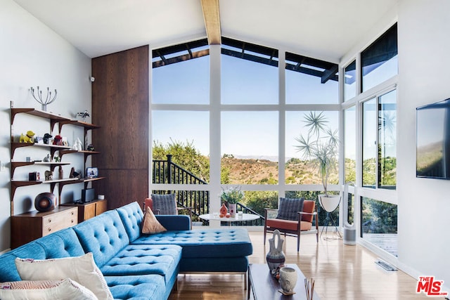 sunroom featuring a wealth of natural light and lofted ceiling with beams