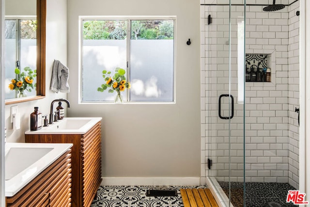 bathroom featuring tile patterned flooring, vanity, and walk in shower