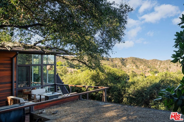 view of yard with a sunroom and a mountain view