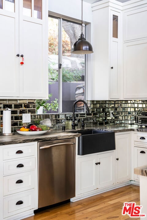 kitchen featuring dishwasher, pendant lighting, backsplash, and white cabinets