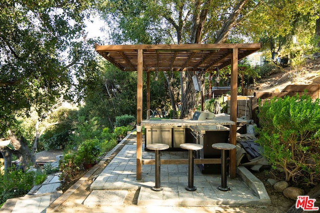 view of patio featuring a pergola and exterior bar