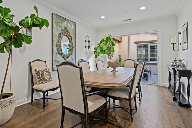 dining room featuring dark hardwood / wood-style floors and crown molding