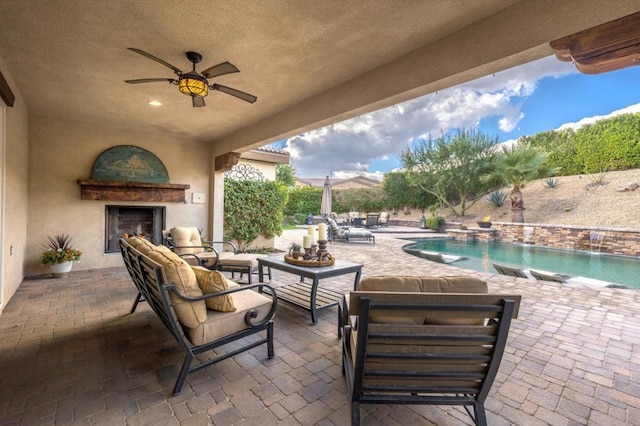 view of patio / terrace with ceiling fan, pool water feature, and an outdoor living space with a fireplace