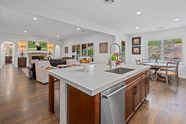 kitchen featuring dark wood-type flooring, sink, stainless steel dishwasher, and a kitchen island with sink