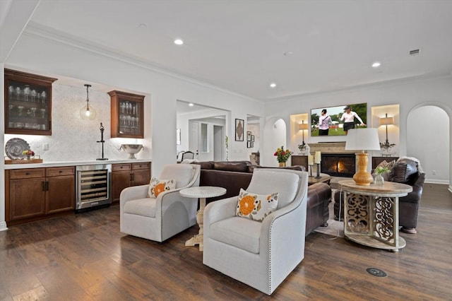 living room featuring beverage cooler, dark hardwood / wood-style flooring, and crown molding