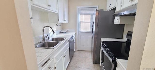 kitchen with stainless steel appliances, white cabinets, sink, and tile countertops