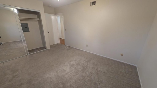 unfurnished bedroom featuring electric panel, a closet, and carpet