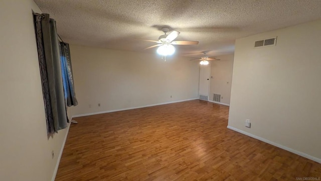 empty room with hardwood / wood-style flooring, a textured ceiling, and ceiling fan