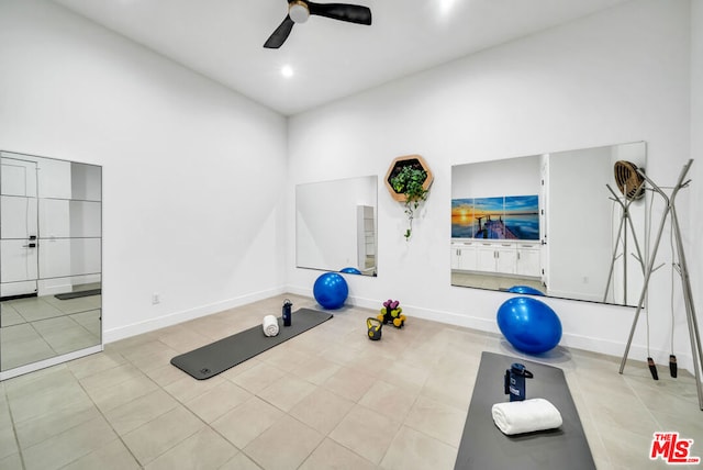 exercise room featuring ceiling fan and light tile patterned flooring