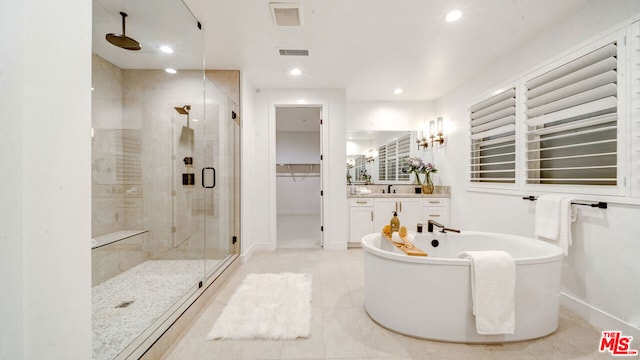 bathroom featuring tile patterned flooring, separate shower and tub, and vanity